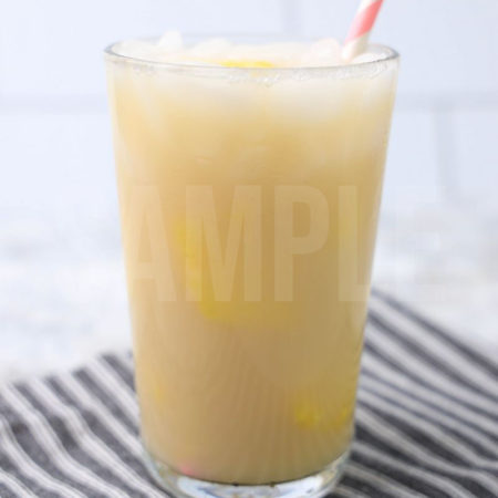 The Paradise Drink comes in a clear glass with a gray striped napkin on a marble backdrop.