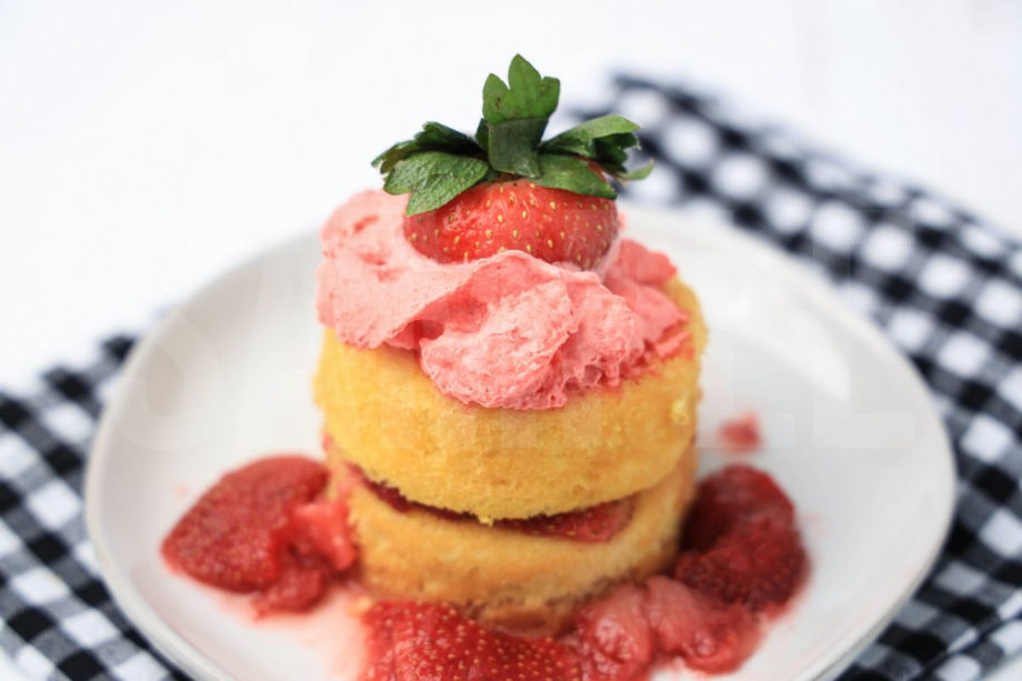 The Strawberry Shortcake comes on a white plate with a plaid napkin on a white wood backdrop.