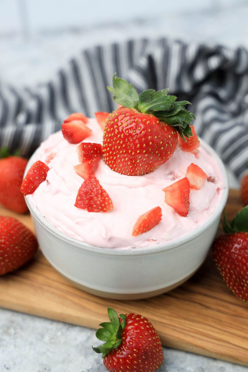 The Strawberry Valentine's Day Dip comes in a stone bowl with a gray striped napkin on a marble wood backdrop.