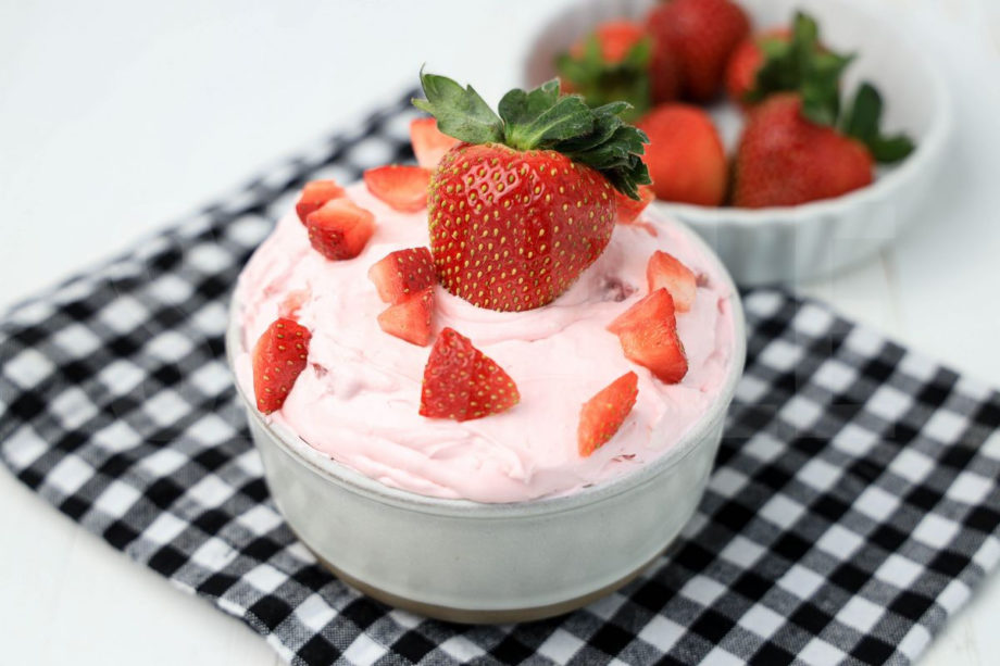 The Strawberry Valentine's Day Dip comes in a stone bowl with a plaid napkin on a white wood backdrop.