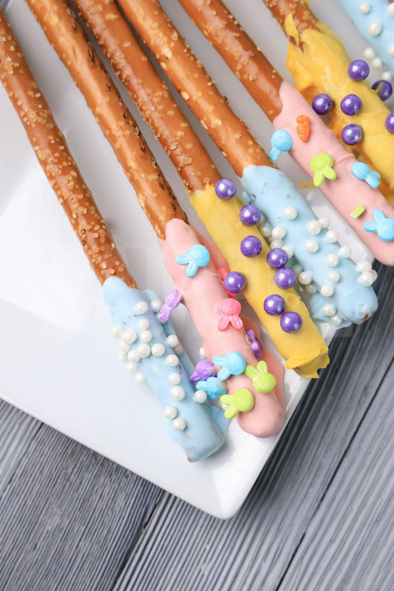 The Easter Pretzel Rods comes on a white plate on a gray wood backdrop.