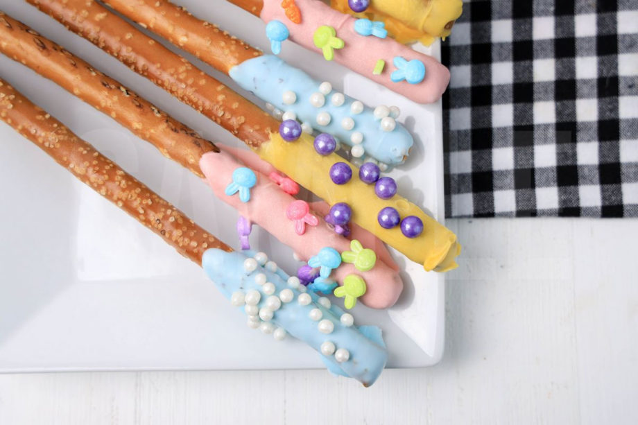 The Easter Pretzel Rods comes on a white plate on a plaid napkin with a white wood backdrop.