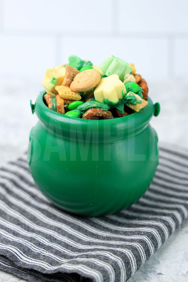 The Leprechaun Bait comes in a green cauldron with a gray striped napkin on a marble backdrop.