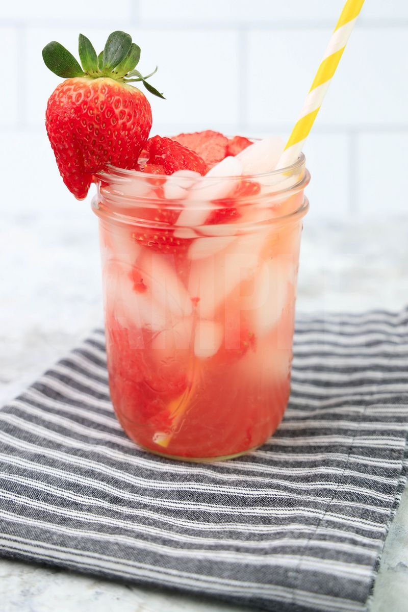 The Starbuck's Strawberry Acai Lemonade Copycat comes in a clear glass with a gray striped napkin on a marble backdrop.