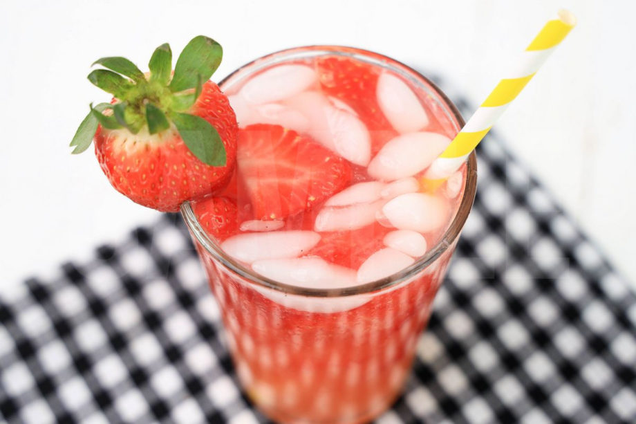 The Starbuck's Strawberry Acai Lemonade Copycat comes in a clear glass with a plaid napkin on a white wood backdrop.