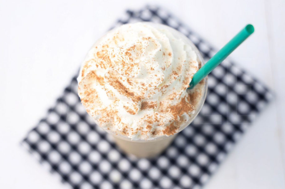 The Chai Crème Frappuccino comes in a venti cup with a plaid napkin on a white wood backdrop.