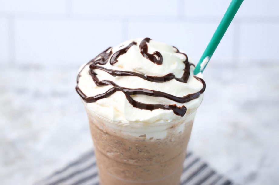 The Double Chocolaty Chip Crème Frappuccino comes in a venti cup with a gray striped napkin on a marble backdrop.