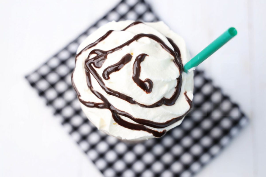 The Double Chocolaty Chip Crème Frappuccino comes in a venti cup with a plaid napkin on a white wood backdrop.