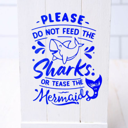 The Do Not Feed The Sharks Cricut Dollar Tree DIY comes pictured on a white wood backdrop.