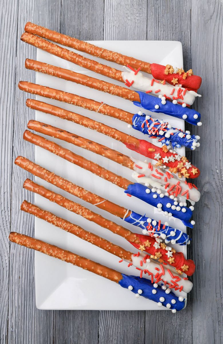 The 4th Of July Pretzel Rods comes on a white plate with a gray wood backdrop.