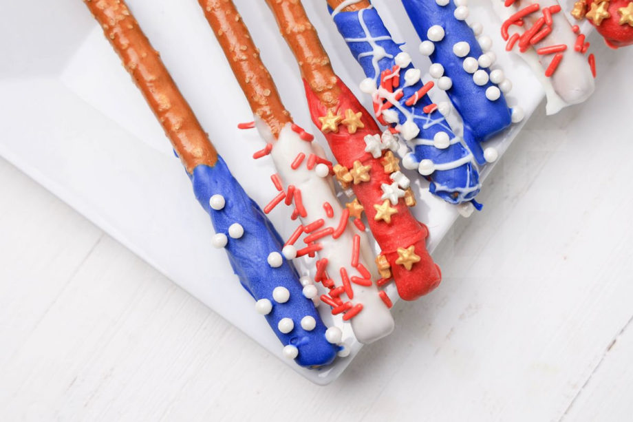 The 4th Of July Pretzel Rods comes on a white plate with a white wood backdrop.