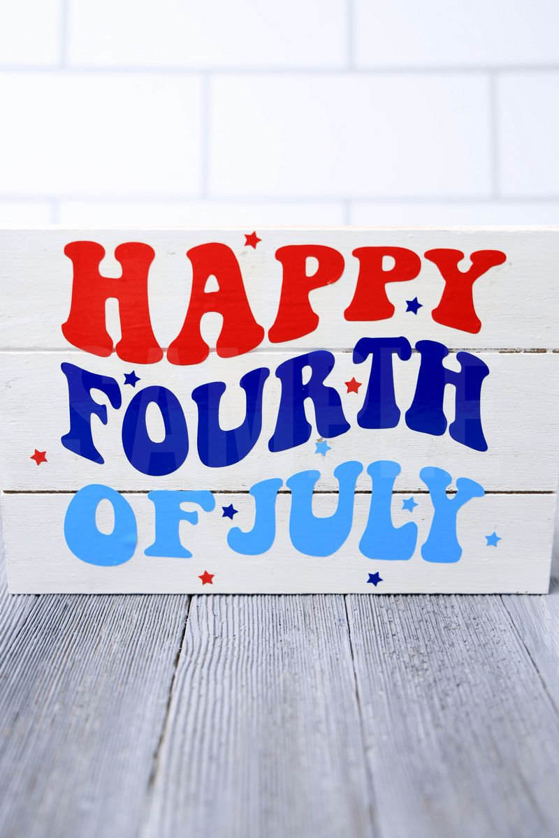 The Happy Fourth Of July Farmhouse Wood Cricut Craft comes pictured on a gray wood backdrop.