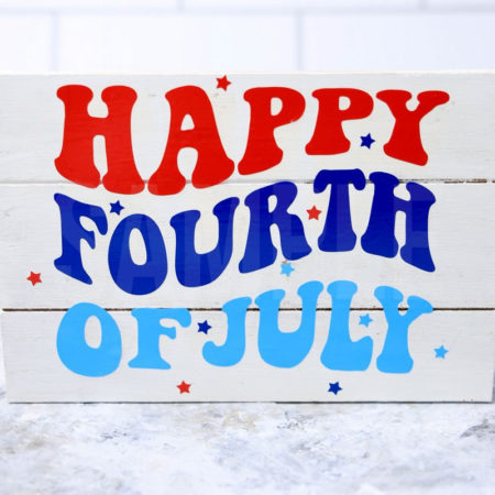 The Happy Fourth Of July Farmhouse Wood Cricut Craft comes pictured on a marble backdrop.
