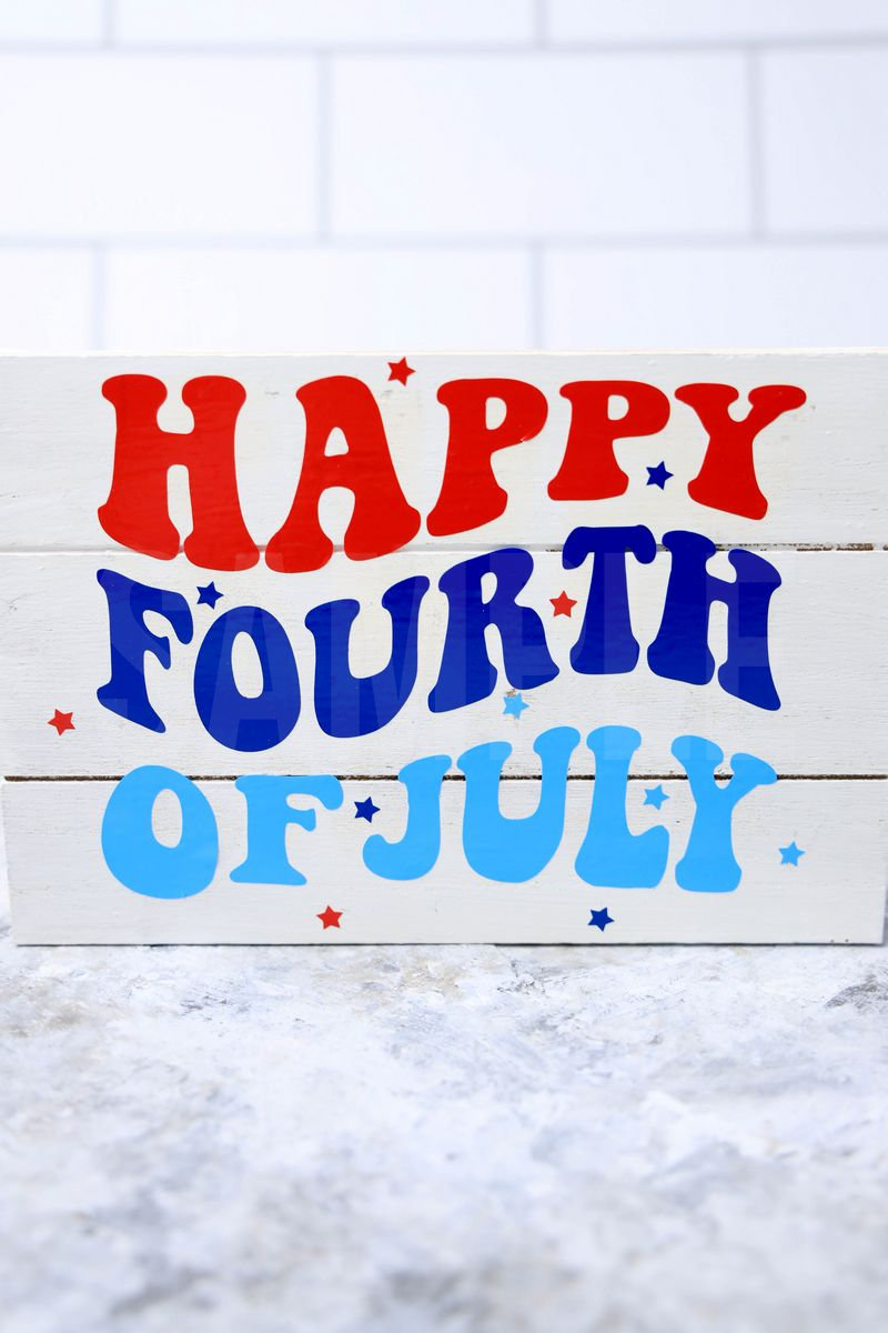 The Happy Fourth Of July Farmhouse Wood Cricut Craft comes pictured on a marble backdrop.