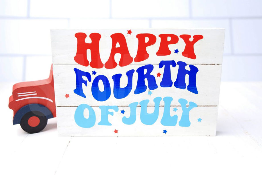 The Happy Fourth Of July Farmhouse Wood Cricut Craft comes pictured on a white wood backdrop.