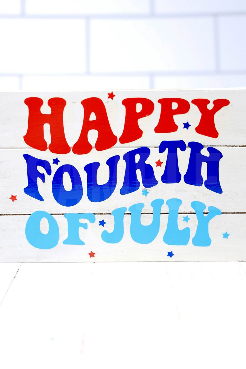 The Happy Fourth Of July Farmhouse Wood Cricut Craft comes pictured on a white wood backdrop.