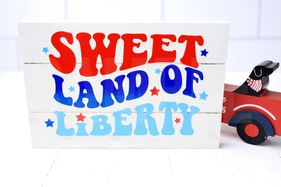 The Sweet Land Of Liberty Farmhouse Wood Cricut Craft comes pictured on a white wood backdrop.