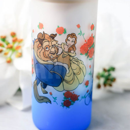 The Beauty and The Beast Glass Can Tumbler Exclusive comes on a gray backdrop.