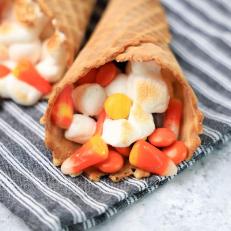 The Halloween Campfire Cones comes a gray striped napkin on a marble backdrop.