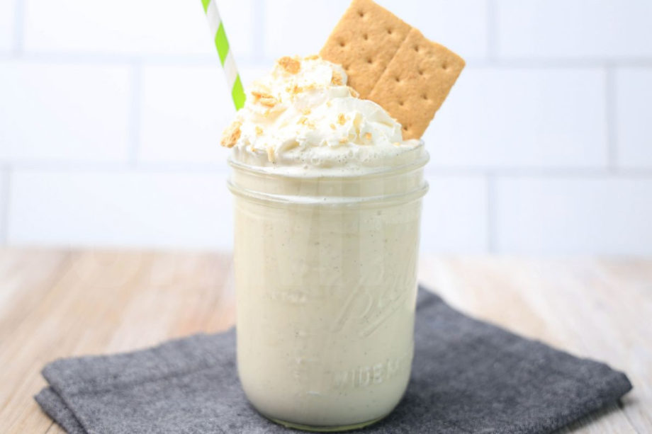 The Key Lime Pie Milkshake comes in a glass jar on a denim napkin on a rustic wood backdrop.
