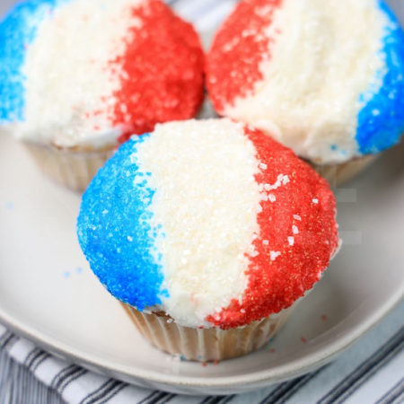 The Snow Cone Cupcakes comes on a white striped napkin on a gray wood backdrop.