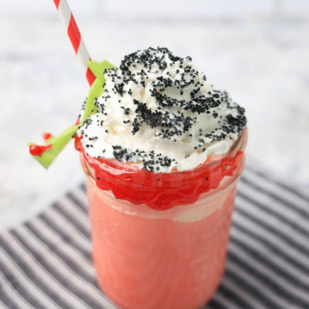 The Vampire Float comes in a mason jar with a gray striped napkin on a marble backdrop.