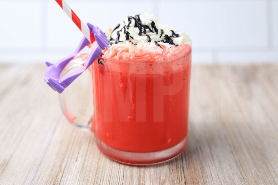 The Vampire Hot Chocolate comes in a glass coffee mug on a rustic wood backdrop.