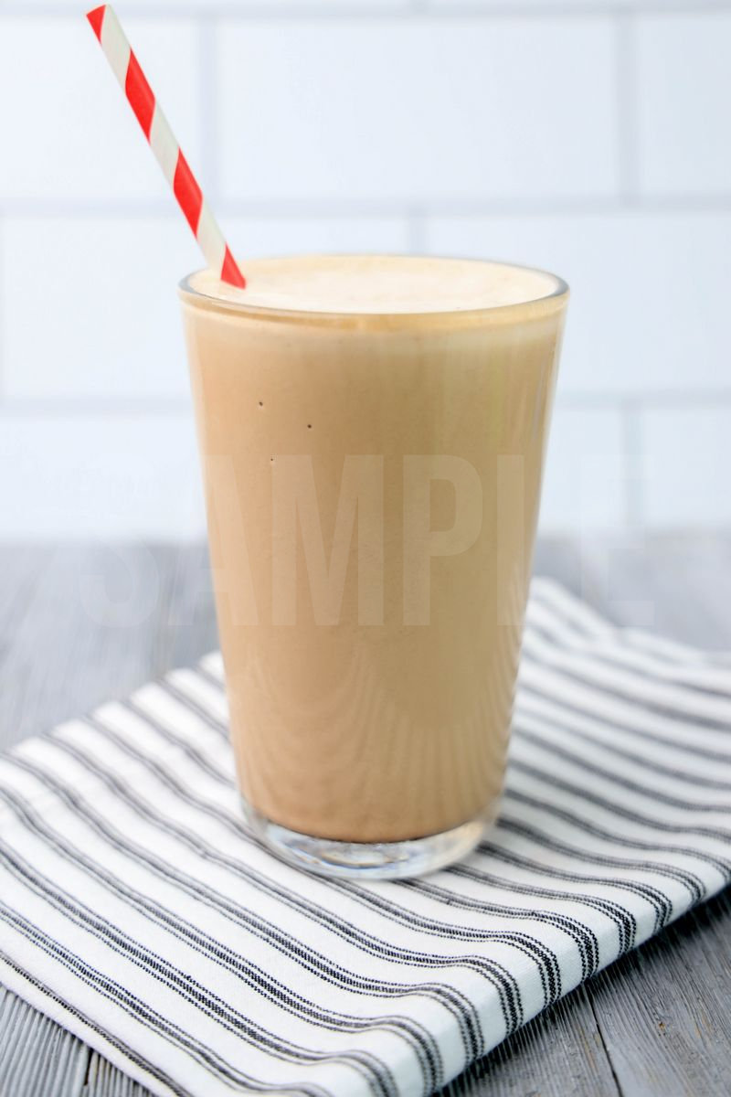 The Wendy's Chocolate Frosty Copycat comes in a glass on a white striped napkin on a gray wood backdrop.