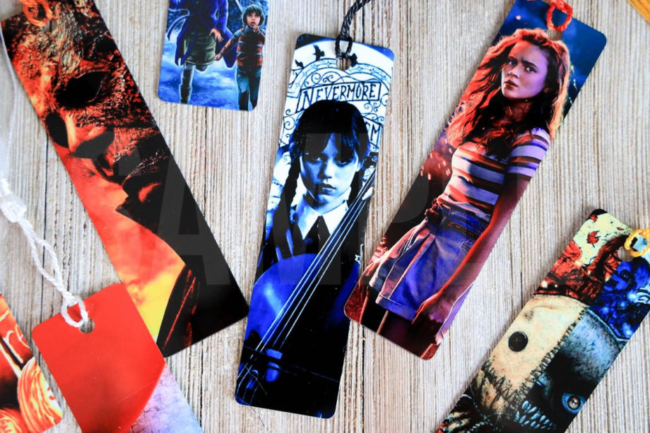 The Wednesday Bookmark Sublimation Exclusive comes on a rustic wood backdrop.