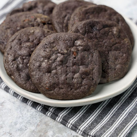 The Wednesday Addams Chocolate Chip Cookies comes a gray striped napkin on a marble backdrop.