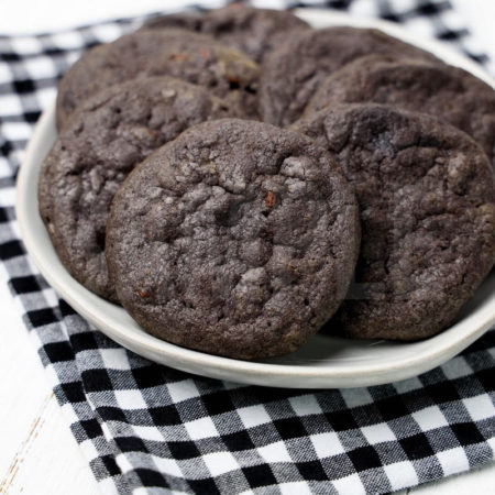 The Wednesday Addams Chocolate Chip Cookies comes a plaid napkin on a white wood backdrop.