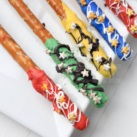 The Harry Potter House Pretzel Rods comes on a white plate on a white wood backdrop.