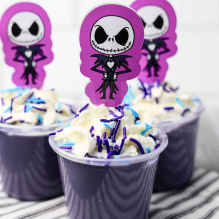 The Jack Skellington Pudding Shots comes on a white striped napkin on a gray wood backdrop.