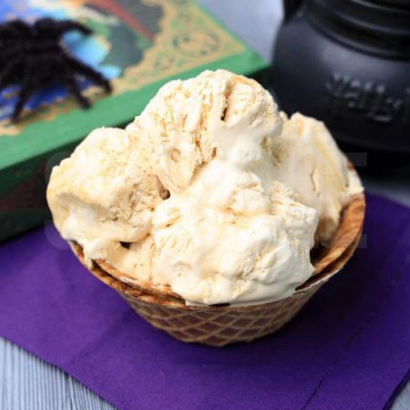 The Harry Potter Butterbeer Ice Cream comes in a waffle bowl with a purple napkin on a gray wood backdrop.