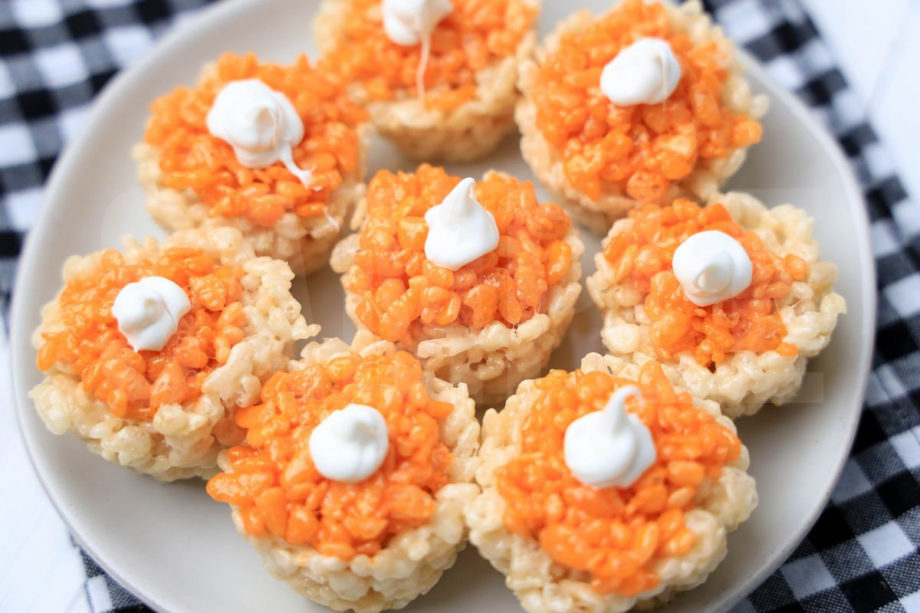 The Pumpkin Pie Rice Krispies Treats come on a white plate with a plaid napkin on a white wood backdrop.