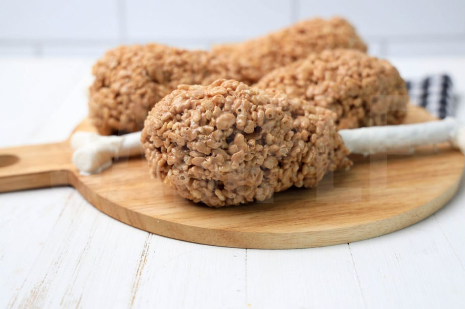 The Turkey Leg Rice Krispies Treats comes on a wood board on a white wood backdrop.