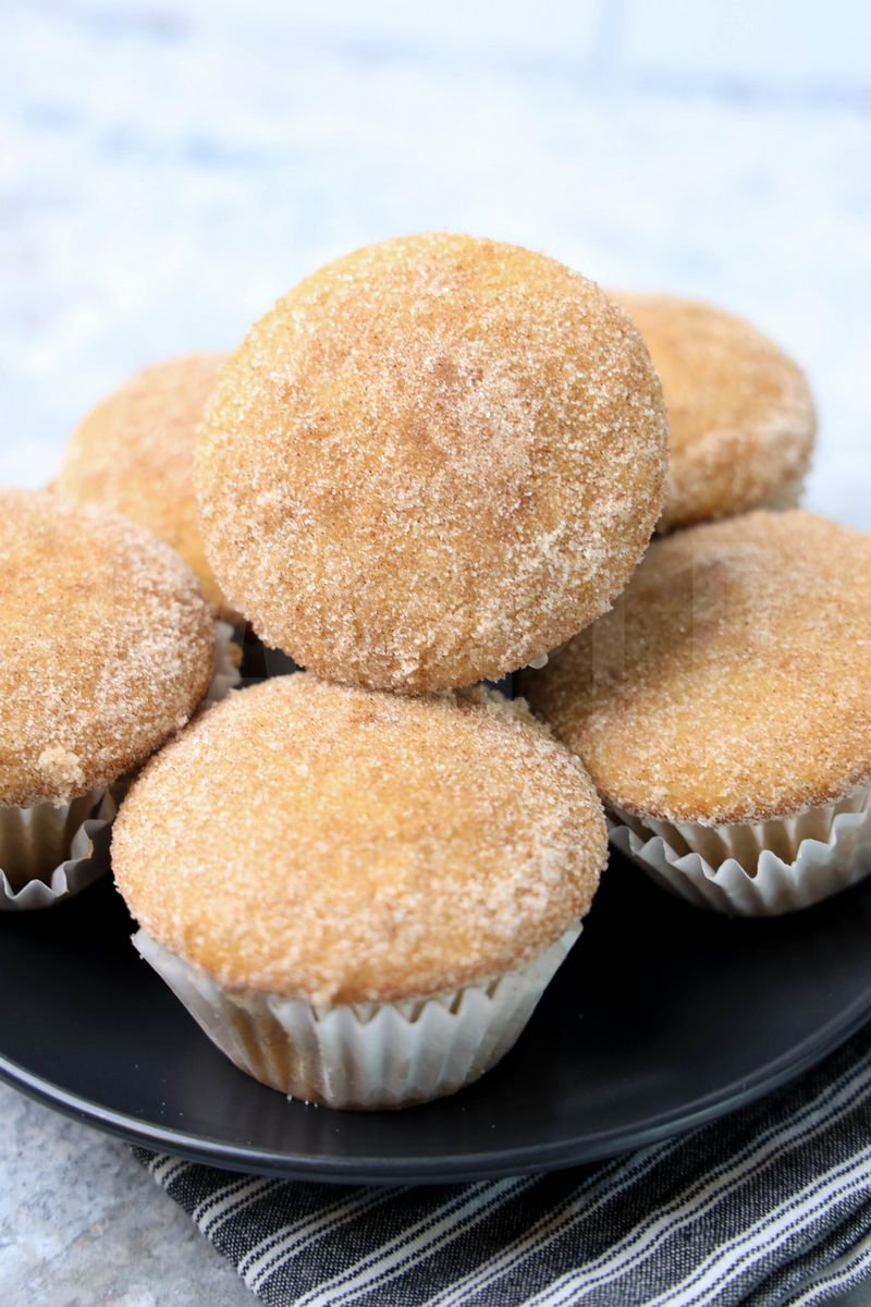 The Apple Cider Muffins comes on a gray plate with a gray striped napkin on a marble backdrop.