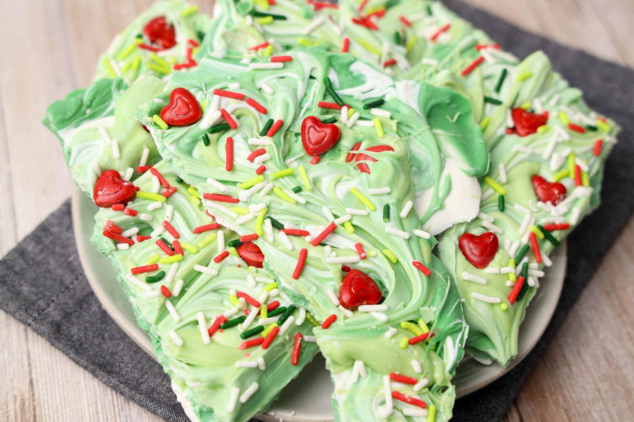 The Grinch Bark comes on a white plate with a denim napkin on a rustic wood backdrop.