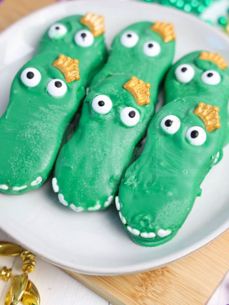 The Mardi Gras Alligators comes on a white plate with wood cutting board and mardi gras beads on white wood backdrop.